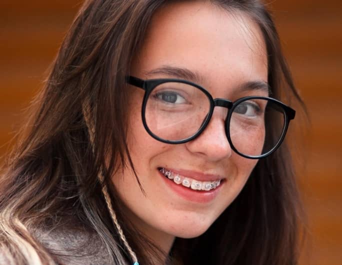young brunette woman with glasses and braces
