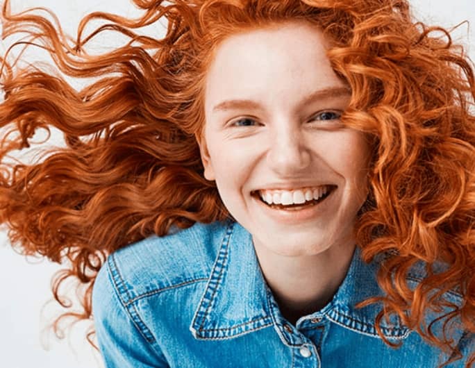 young curly redhead women with big smile