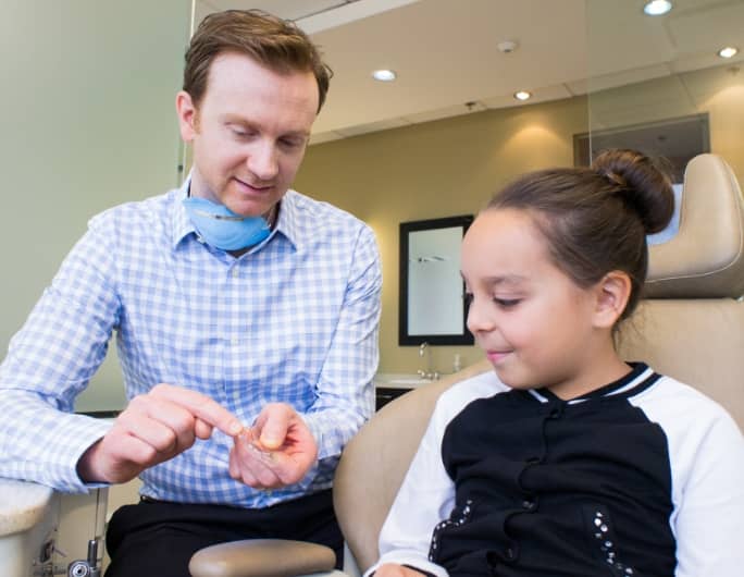 Dr Frédéric Lavoie presenting invisalign to a young girl